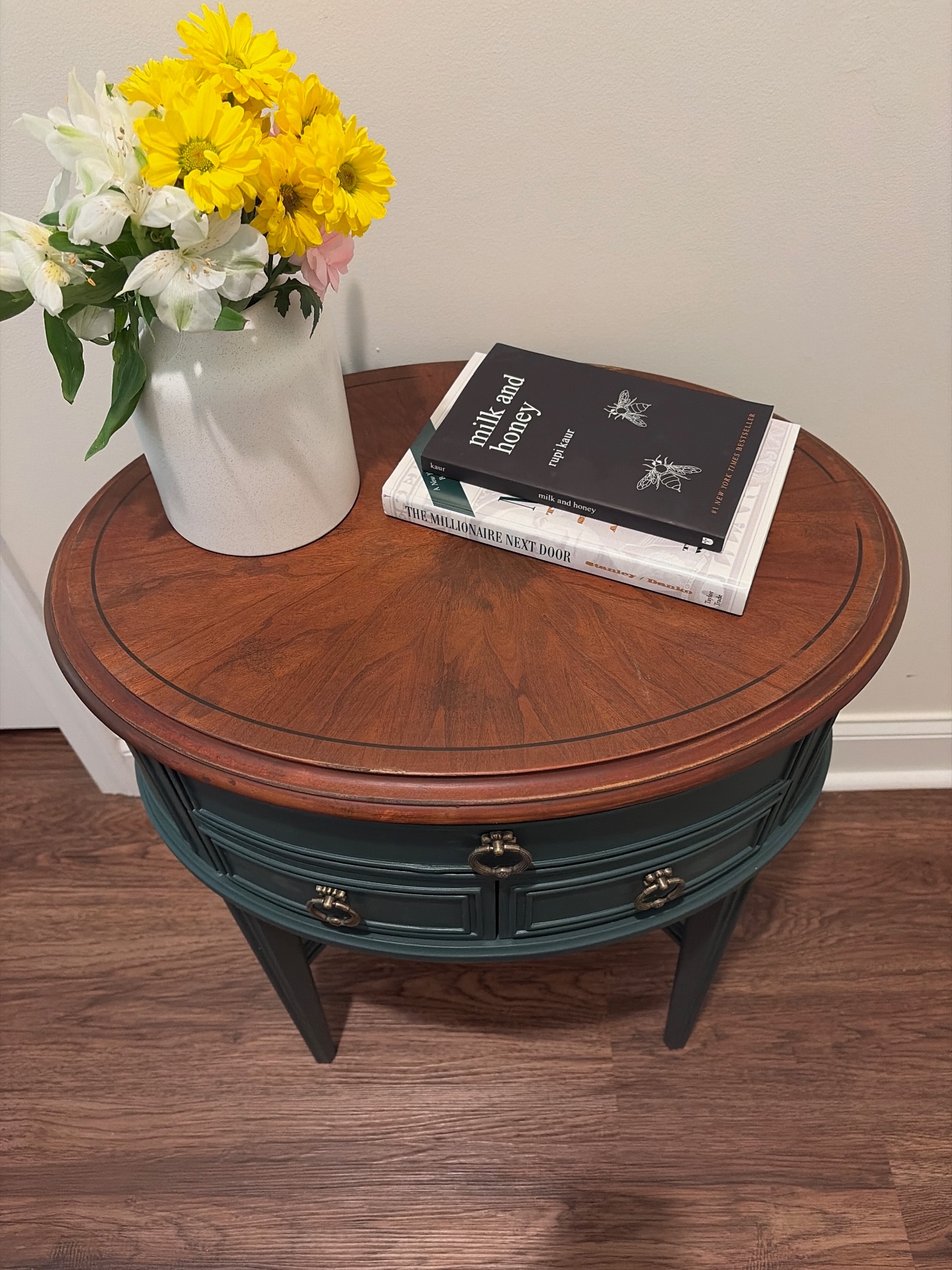 Refinished round side table with rich wood top and deep green base, styled with fresh flowers